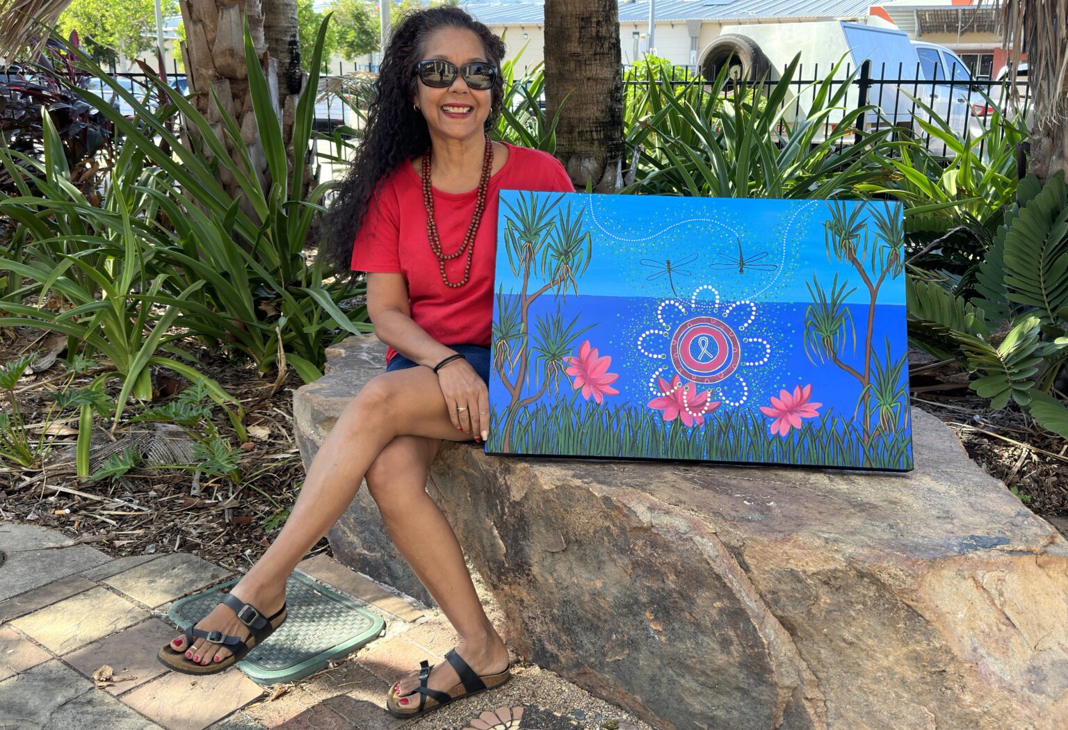 Aboriginal Artists Darlene Devery holding her painting called Good Ways created for NT Mental Health Week 2023